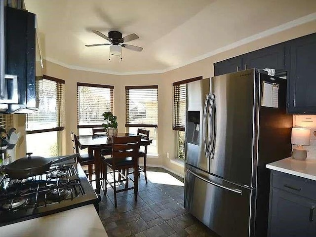 kitchen with stainless steel refrigerator with ice dispenser, stone tile flooring, light countertops, ornamental molding, and a ceiling fan