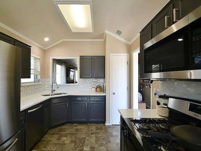 kitchen featuring ornamental molding, stainless steel appliances, a sink, and light countertops