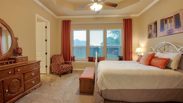 bedroom featuring a raised ceiling, light colored carpet, ornamental molding, a ceiling fan, and baseboards