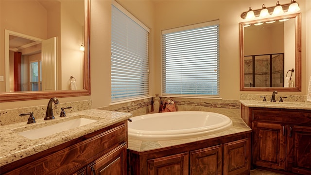 full bathroom with a shower with shower door, two vanities, a sink, and a bath