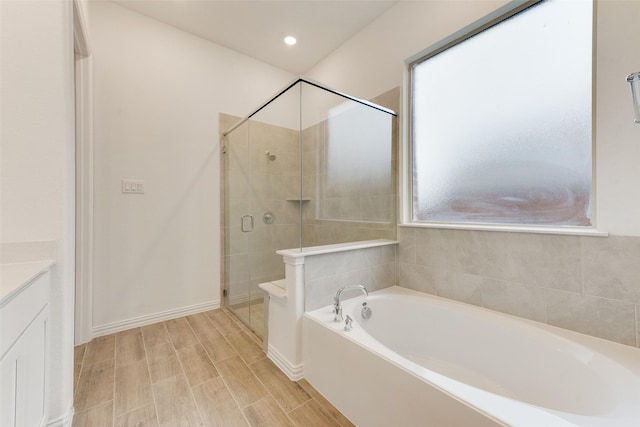 full bath with a garden tub, recessed lighting, vanity, baseboards, and a stall shower