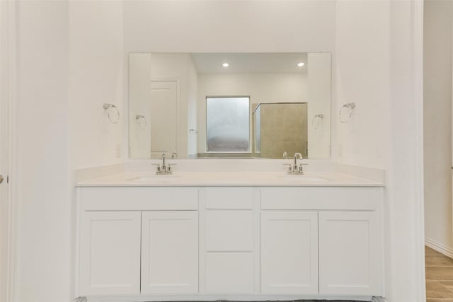 full bathroom with a stall shower, a sink, recessed lighting, and double vanity