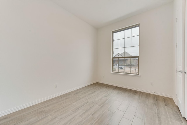 empty room with baseboards and light wood finished floors