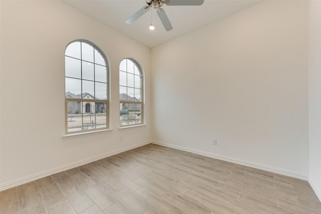 unfurnished room featuring light wood-style floors, ceiling fan, and baseboards