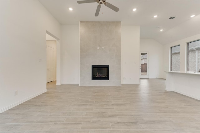 unfurnished living room with ceiling fan, visible vents, baseboards, light wood-type flooring, and a tiled fireplace