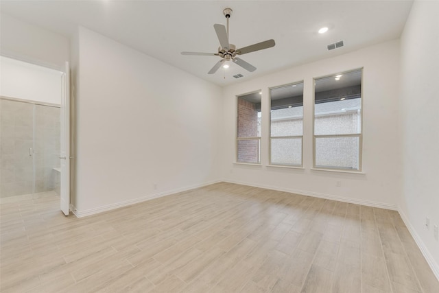 unfurnished room with light wood-style floors, visible vents, baseboards, and a ceiling fan