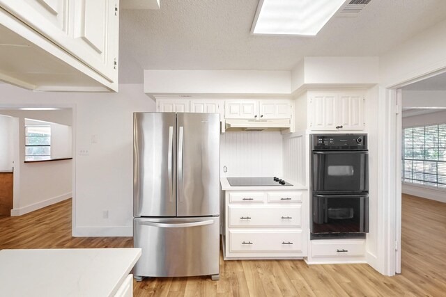 kitchen with white cabinetry, baseboards, light wood finished floors, and black appliances