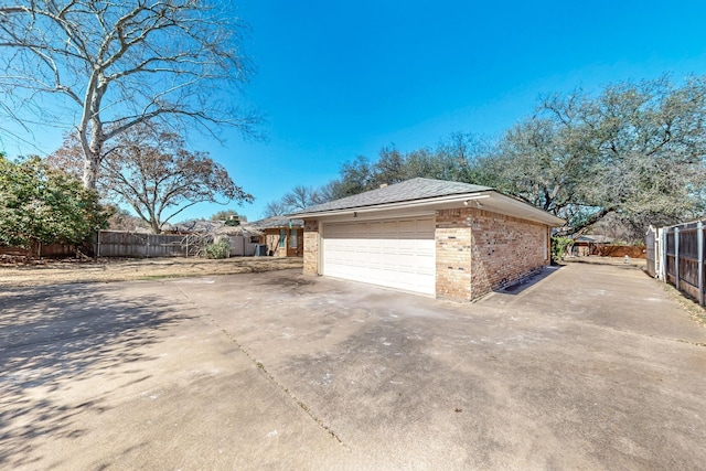 garage with driveway and fence