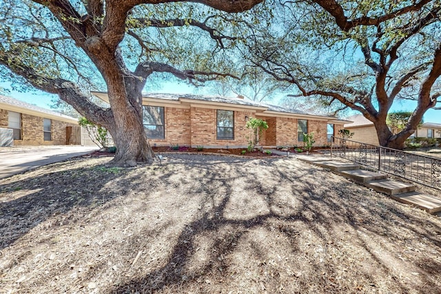 ranch-style house featuring fence and brick siding