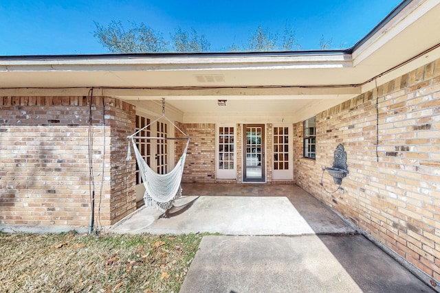 doorway to property with a patio area and brick siding