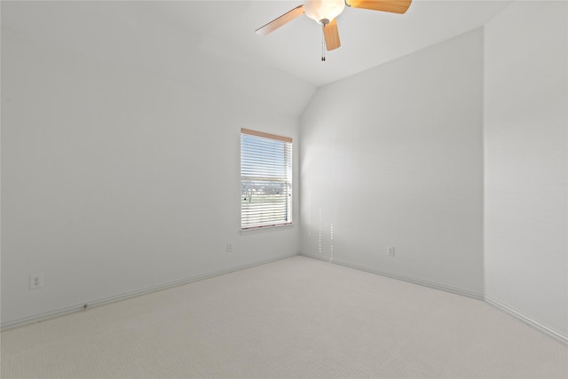 empty room with lofted ceiling, baseboards, a ceiling fan, and light colored carpet