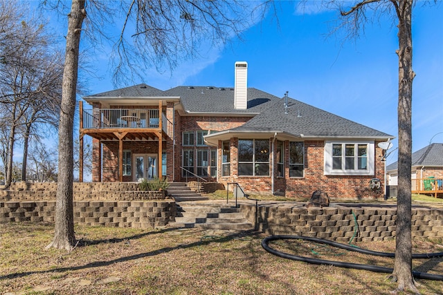 rear view of property featuring a shingled roof, a chimney, french doors, and brick siding