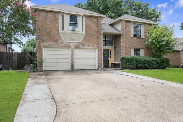 traditional-style home with brick siding, concrete driveway, a front yard, fence, and a garage