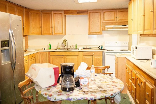 kitchen featuring light countertops, white appliances, a sink, and under cabinet range hood