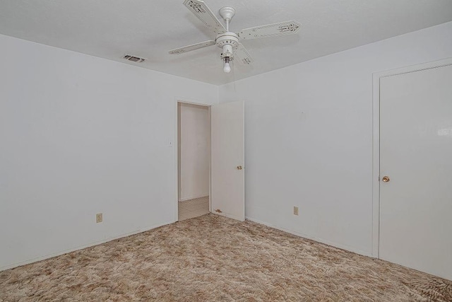 carpeted spare room with ceiling fan and visible vents