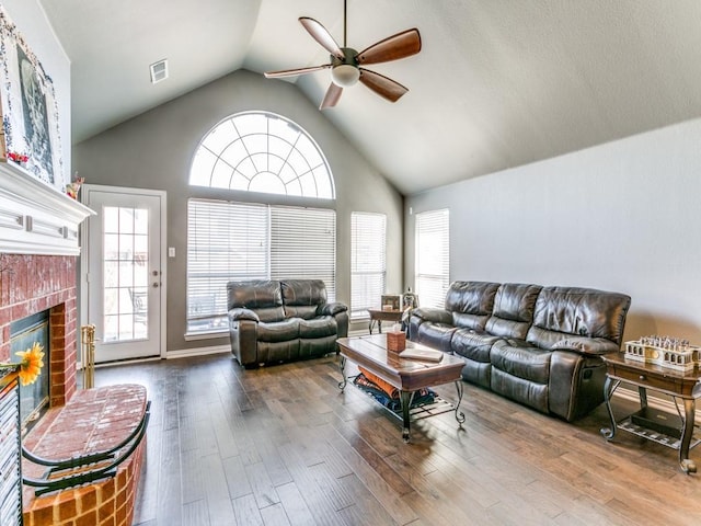 living room featuring visible vents, a fireplace, a ceiling fan, and wood finished floors