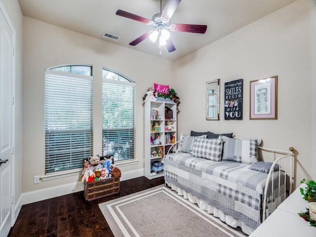 living area with a ceiling fan, visible vents, baseboards, and wood finished floors