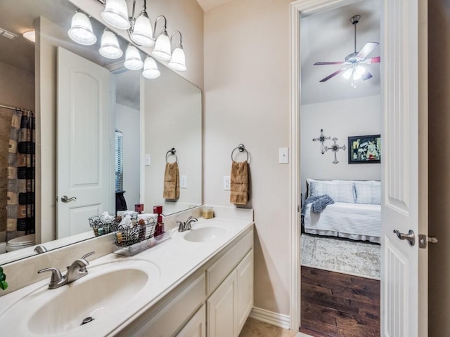 bathroom featuring ensuite bathroom, double vanity, ceiling fan with notable chandelier, and a sink