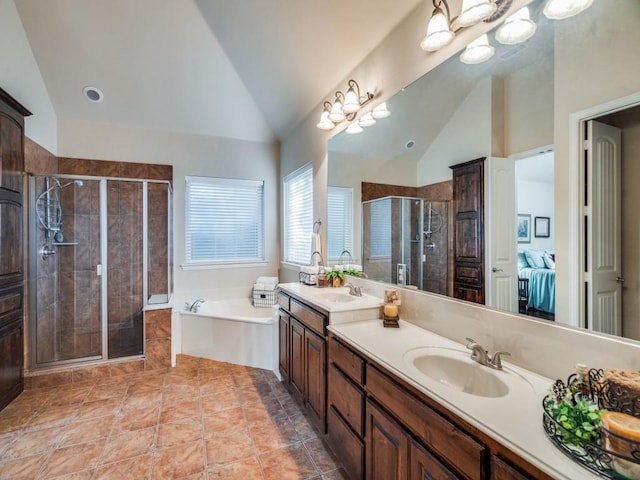 ensuite bathroom featuring double vanity, vaulted ceiling, a sink, a shower stall, and a bath