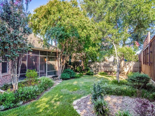 view of yard with a fenced backyard and a sunroom