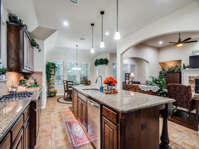 kitchen featuring a center island with sink, dishwasher, lofted ceiling, open floor plan, and a sink