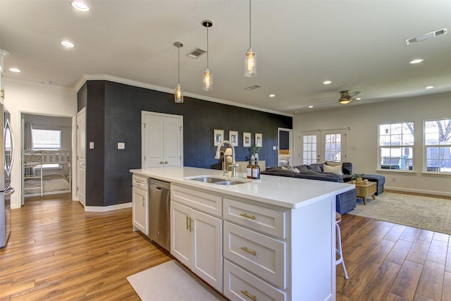 kitchen featuring stainless steel appliances, white cabinets, visible vents, and a sink