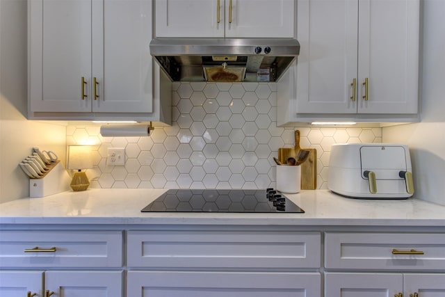 kitchen with tasteful backsplash, black electric stovetop, ventilation hood, and light stone countertops