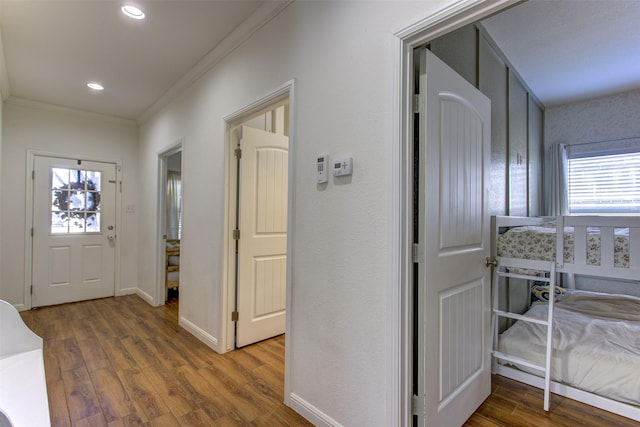 foyer entrance with recessed lighting, crown molding, baseboards, and wood finished floors