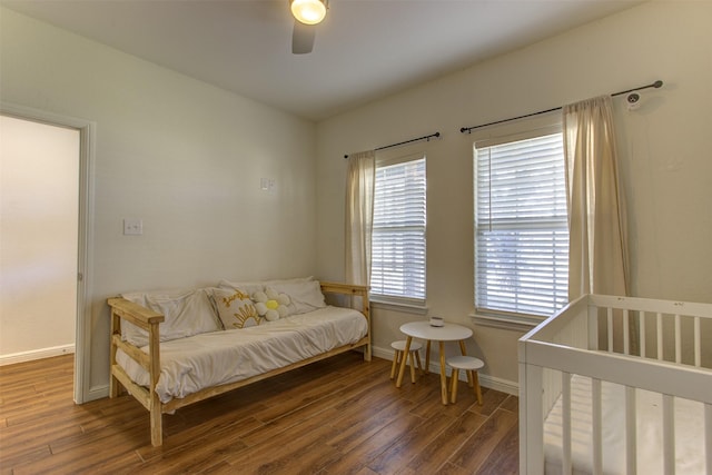 bedroom featuring ceiling fan, baseboards, and wood finished floors