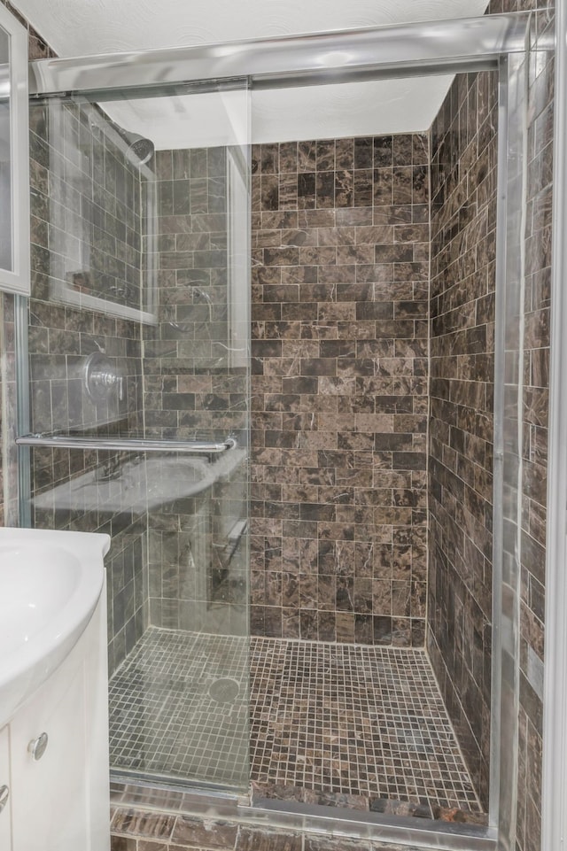 bathroom featuring a shower stall and vanity