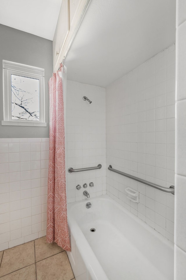 bathroom with tile patterned flooring, a wainscoted wall, tile walls, and shower / tub combo