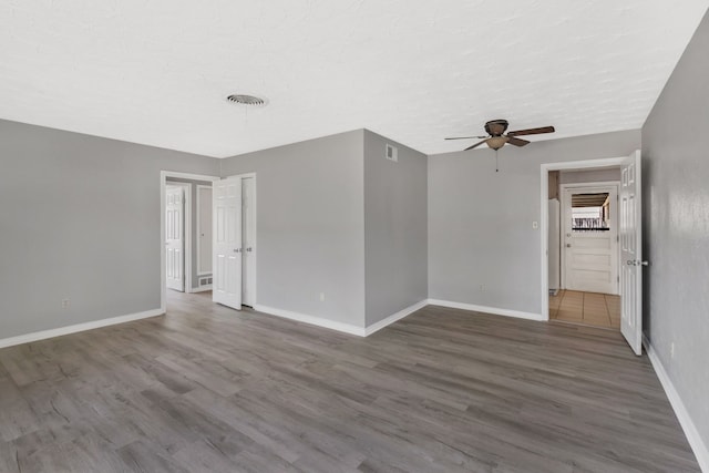 unfurnished room with baseboards and wood finished floors