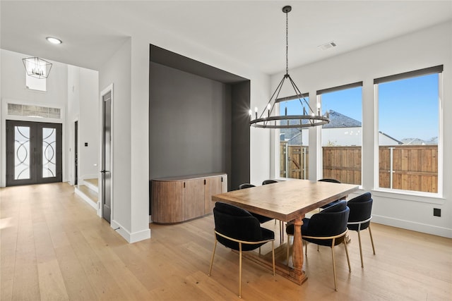 dining room featuring a chandelier, french doors, visible vents, and light wood-style floors