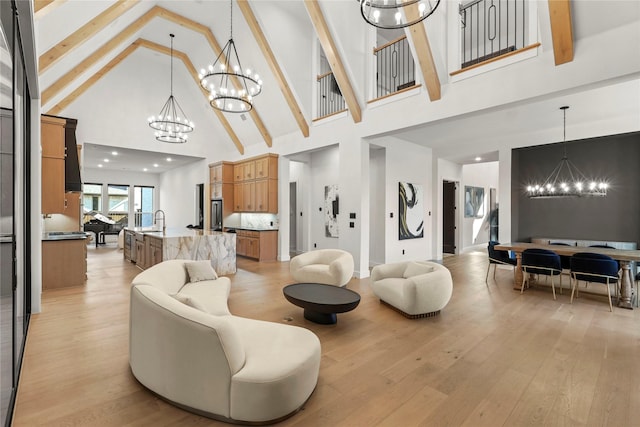 living area with light wood-type flooring, high vaulted ceiling, a notable chandelier, and beamed ceiling