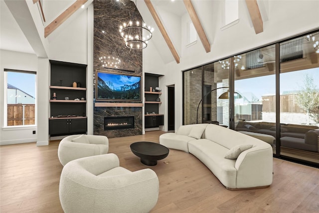 living room with a healthy amount of sunlight, a premium fireplace, high vaulted ceiling, and wood finished floors