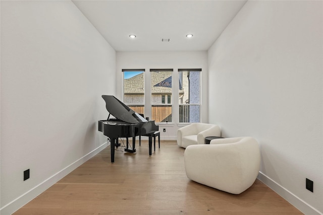 sitting room with light wood-type flooring, visible vents, baseboards, and recessed lighting