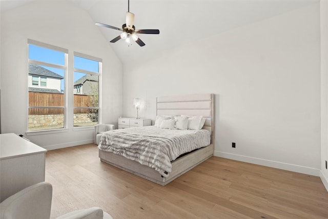 bedroom featuring high vaulted ceiling, light wood-type flooring, and baseboards