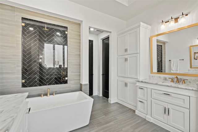 bathroom featuring a stall shower, a freestanding tub, and vanity