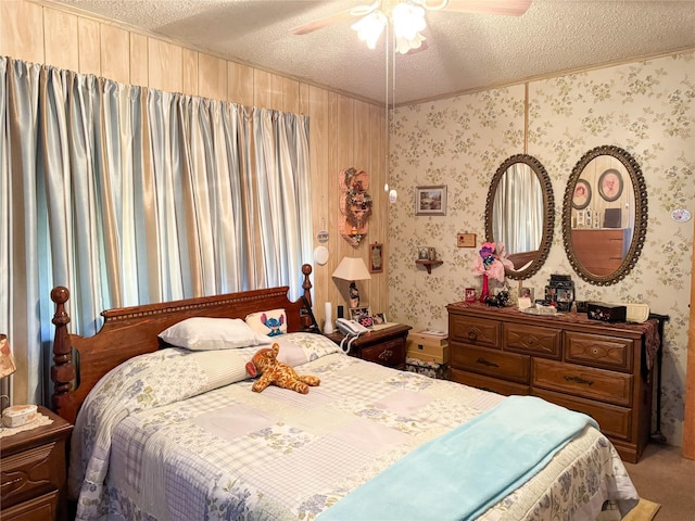 carpeted bedroom featuring wallpapered walls, ceiling fan, and a textured ceiling