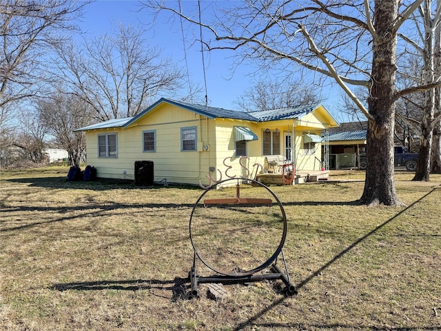 view of front facade featuring metal roof and a front yard