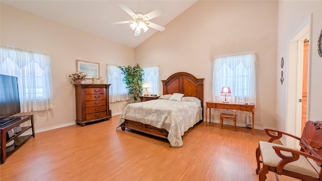 bedroom with high vaulted ceiling, multiple windows, baseboards, and wood finished floors