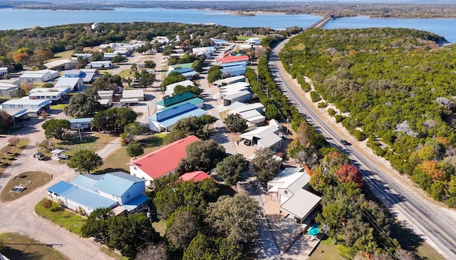 drone / aerial view with a residential view, a water view, and a forest view