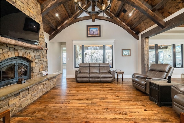 living area with high vaulted ceiling, a stone fireplace, wood finished floors, and wood ceiling