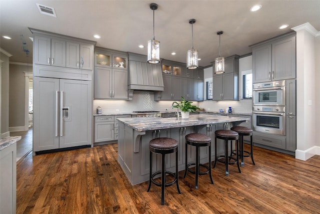 kitchen with visible vents, appliances with stainless steel finishes, gray cabinets, and premium range hood