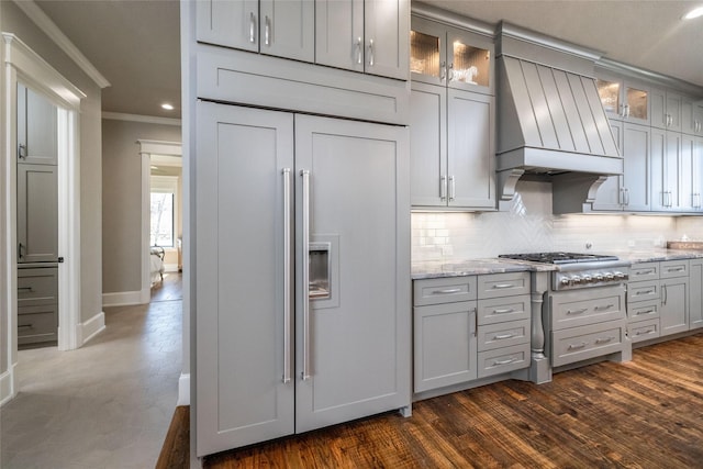 kitchen with stainless steel gas cooktop, custom range hood, tasteful backsplash, dark wood finished floors, and crown molding