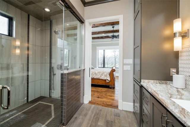 full bath with a ceiling fan, ensuite bath, wood finished floors, vanity, and a shower stall