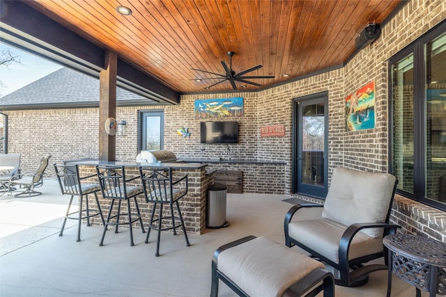 view of patio with a grill, ceiling fan, and exterior kitchen