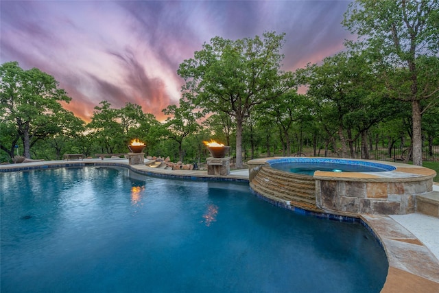 view of pool featuring a pool with connected hot tub and fence