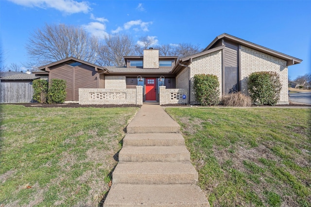 mid-century inspired home featuring a chimney, a front lawn, and brick siding