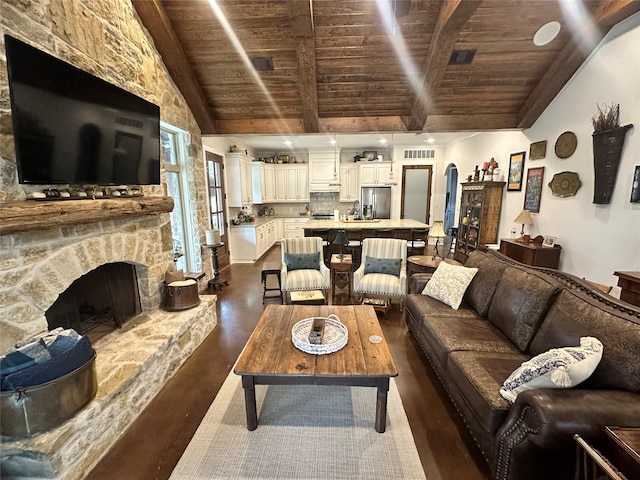 living room featuring visible vents, a stone fireplace, high vaulted ceiling, wooden ceiling, and beamed ceiling